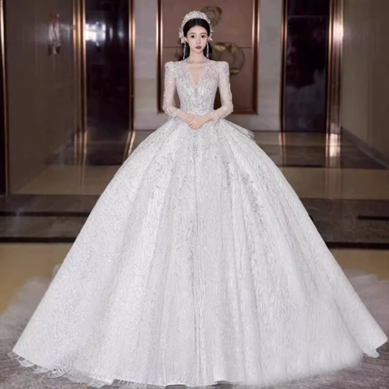 فستان زفاف فرنسي الطراز بفتحة صدر على شكل حرف V عميقة، موديل جديد لعام 2026، فستان زفاف أبيض فاخر بأكمام طويلة وذيل طويل